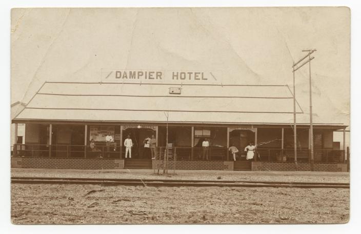 A man standing in front of a hotel. 